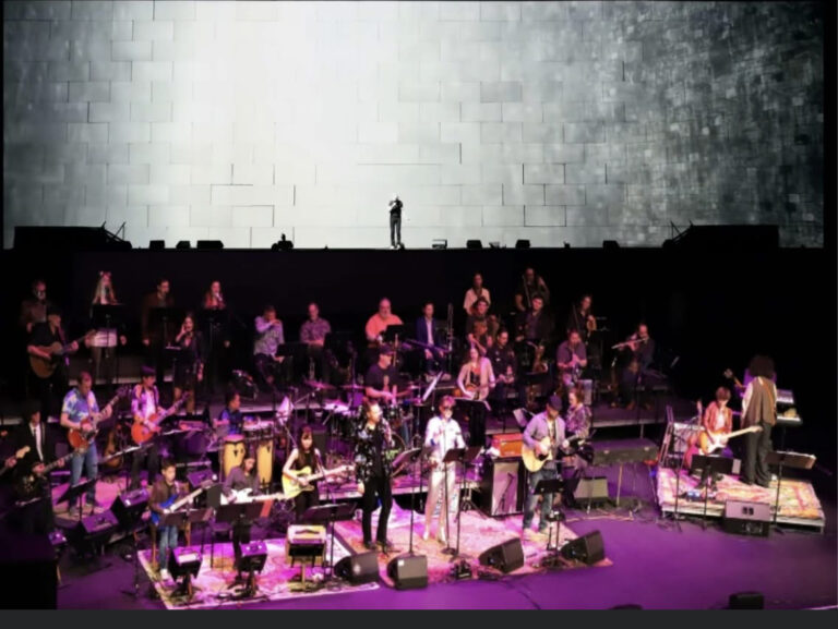 a group of people on stage in front of a large screen