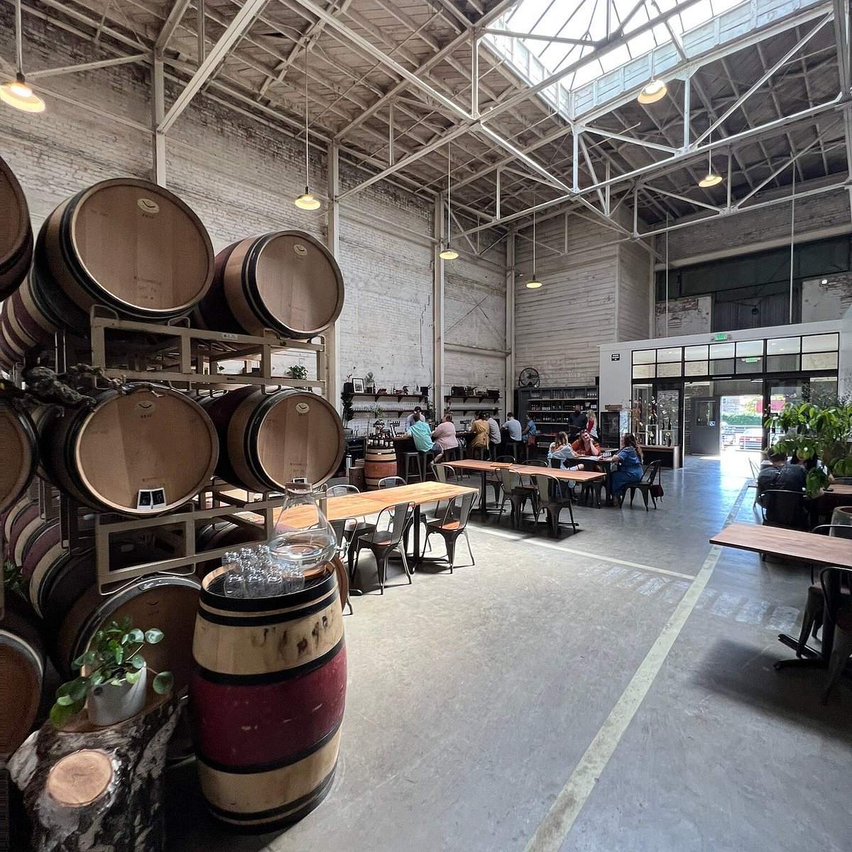 wine barrels in a warehouse with tables and chairs