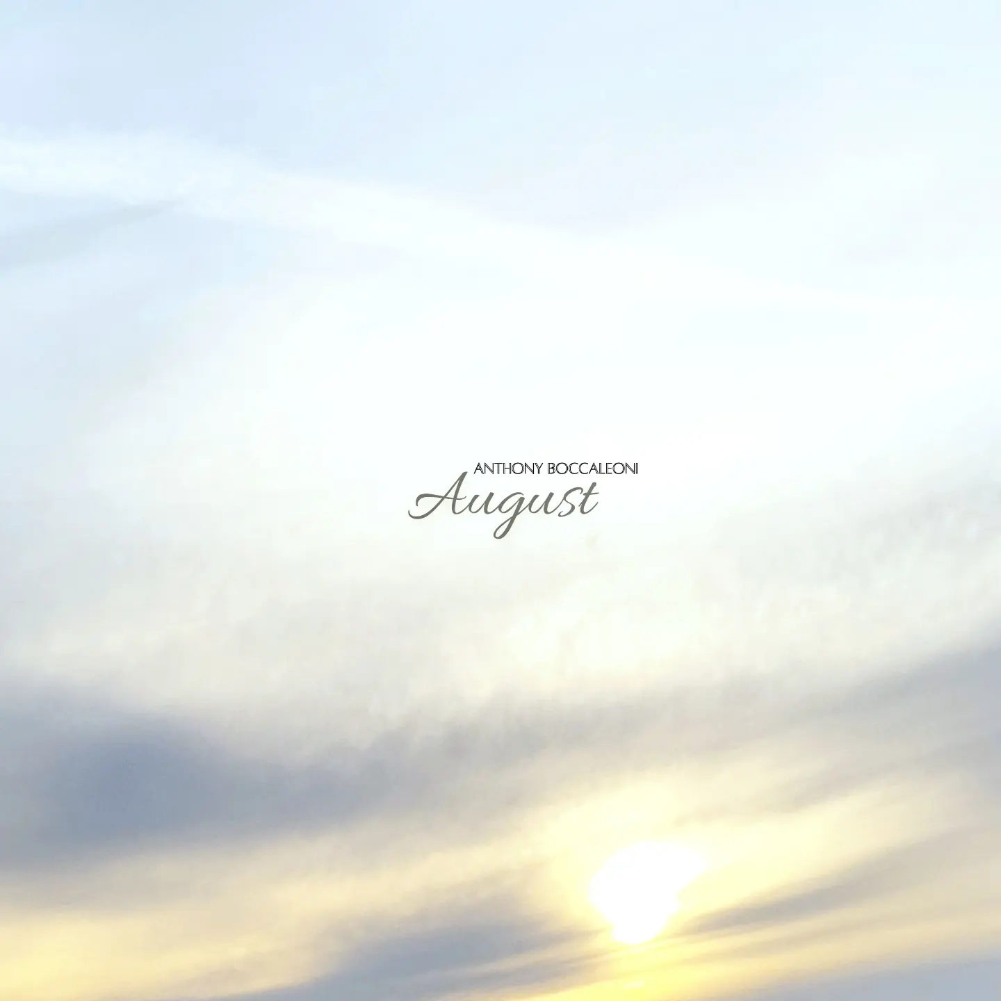 the sun is setting over the ocean with clouds in the background