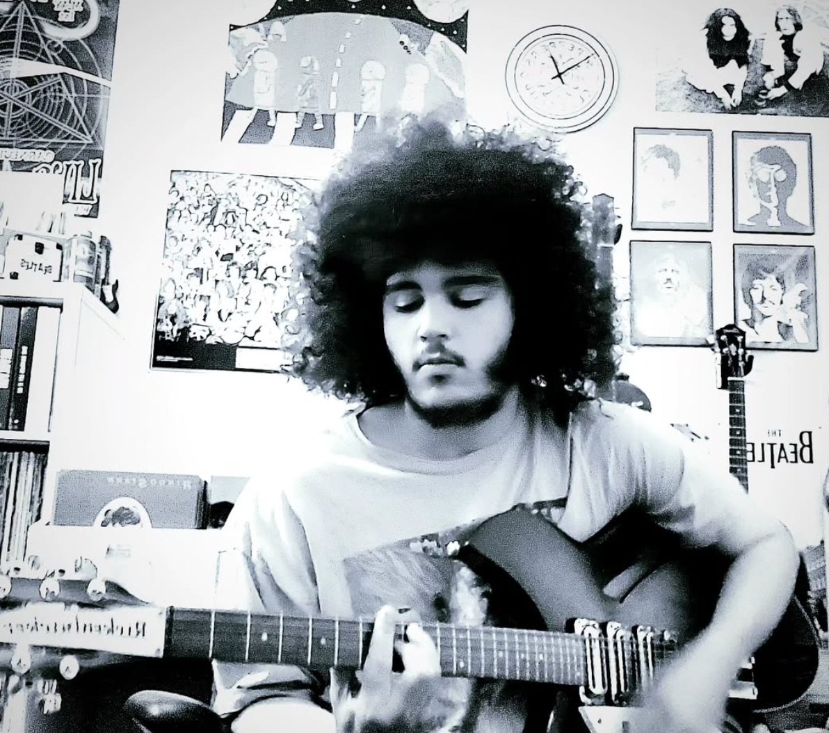 a black and white photo of a man playing an acoustic guitar