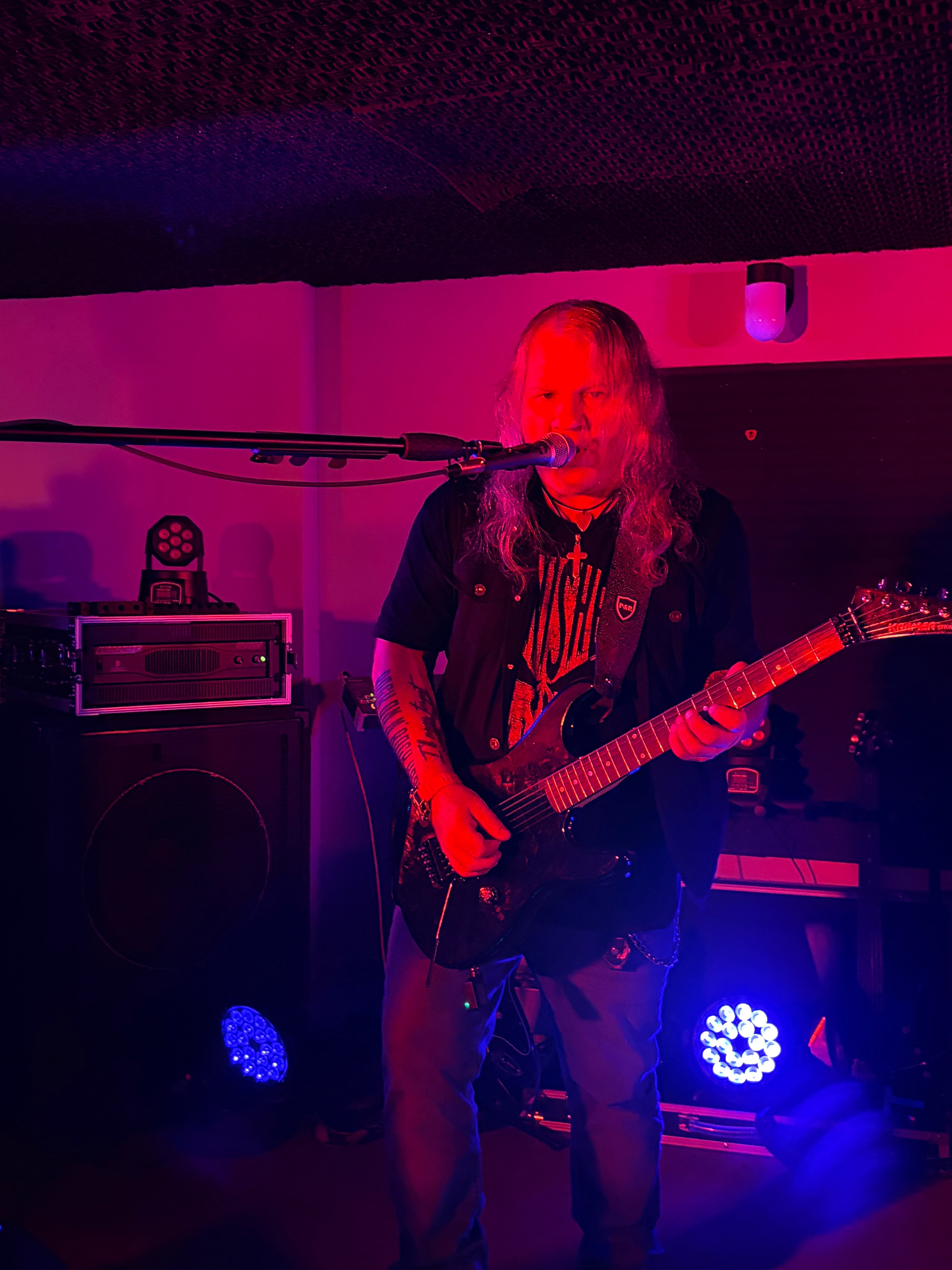 a man playing a guitar in a dark room