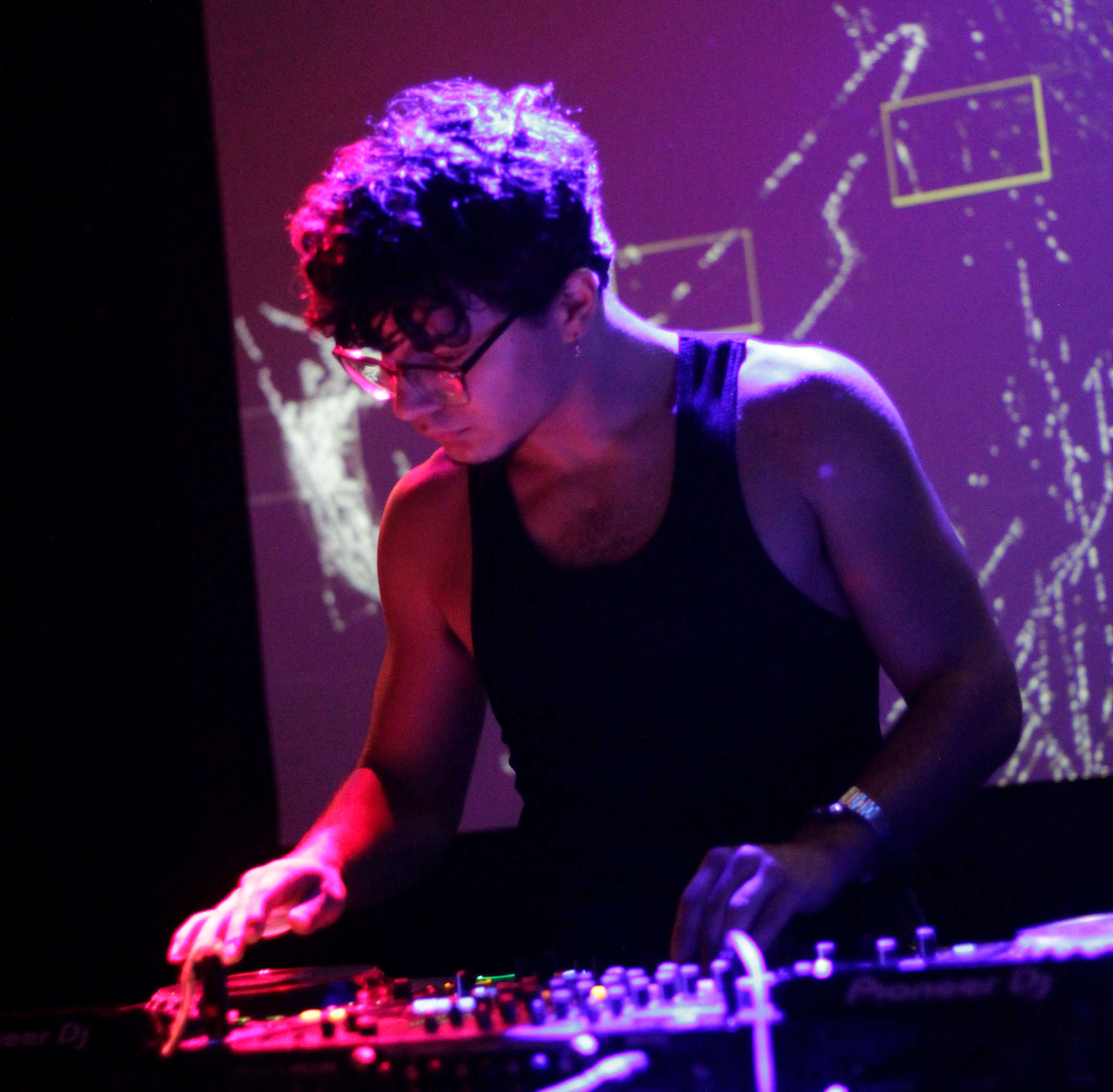 a man in a tank top playing a dj set