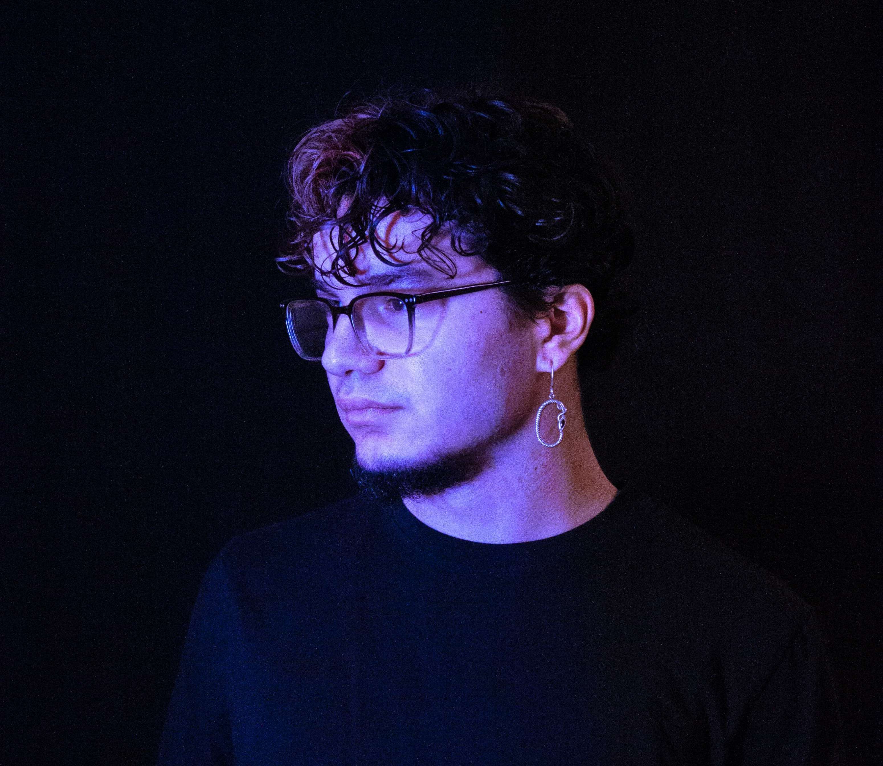 a man with glasses is standing in front of a black background