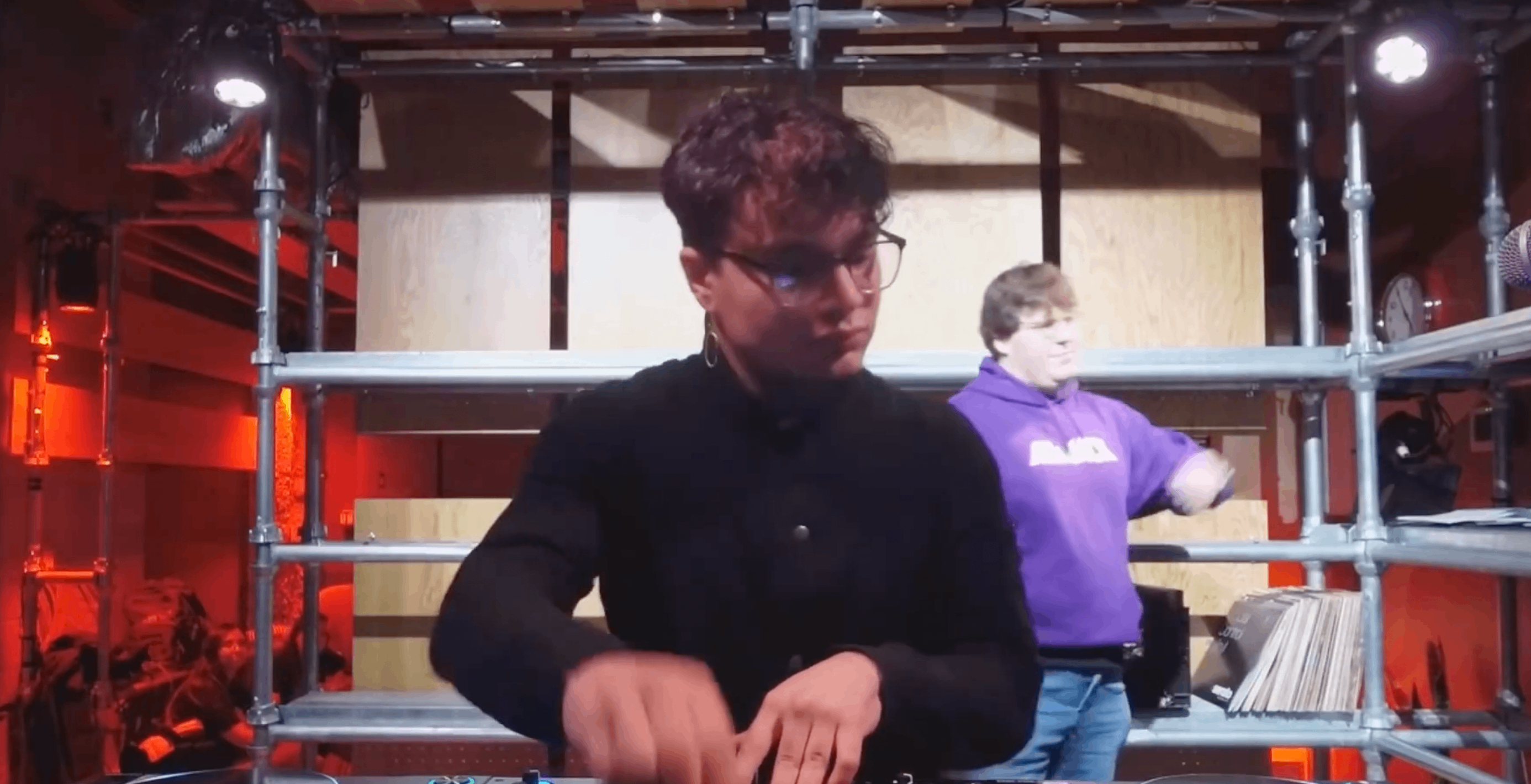 a man in glasses is djing in a room