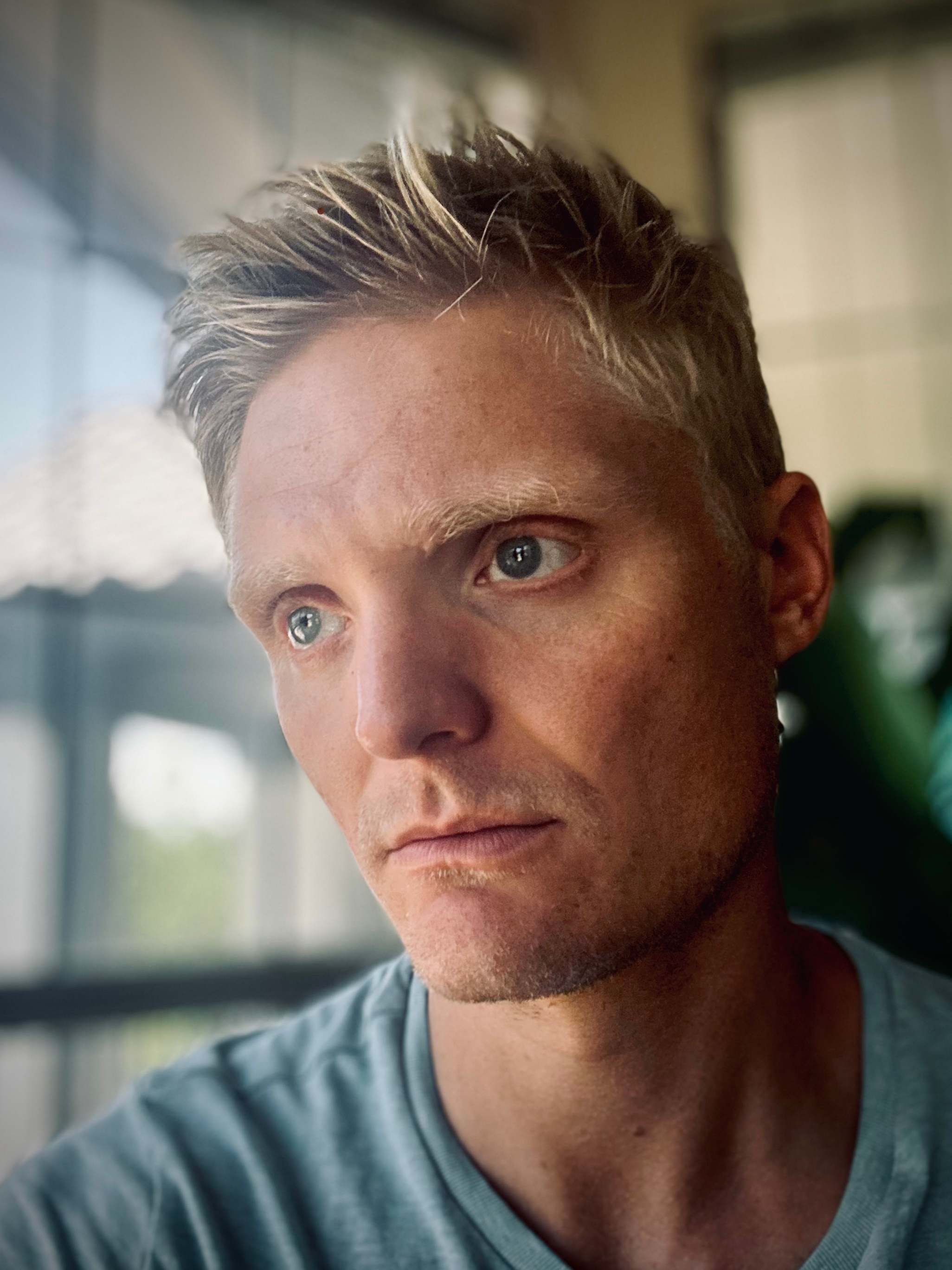 a man in a blue shirt is staring at the camera