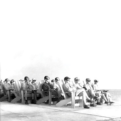 a group of people sitting in chairs on the beach