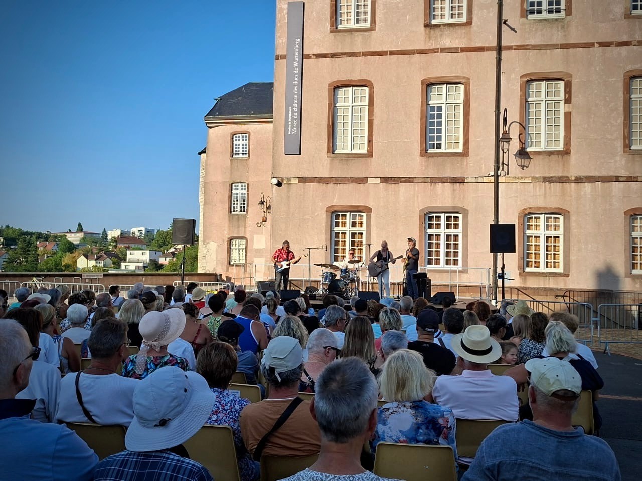 a crowd of people watching a concert in front of a building