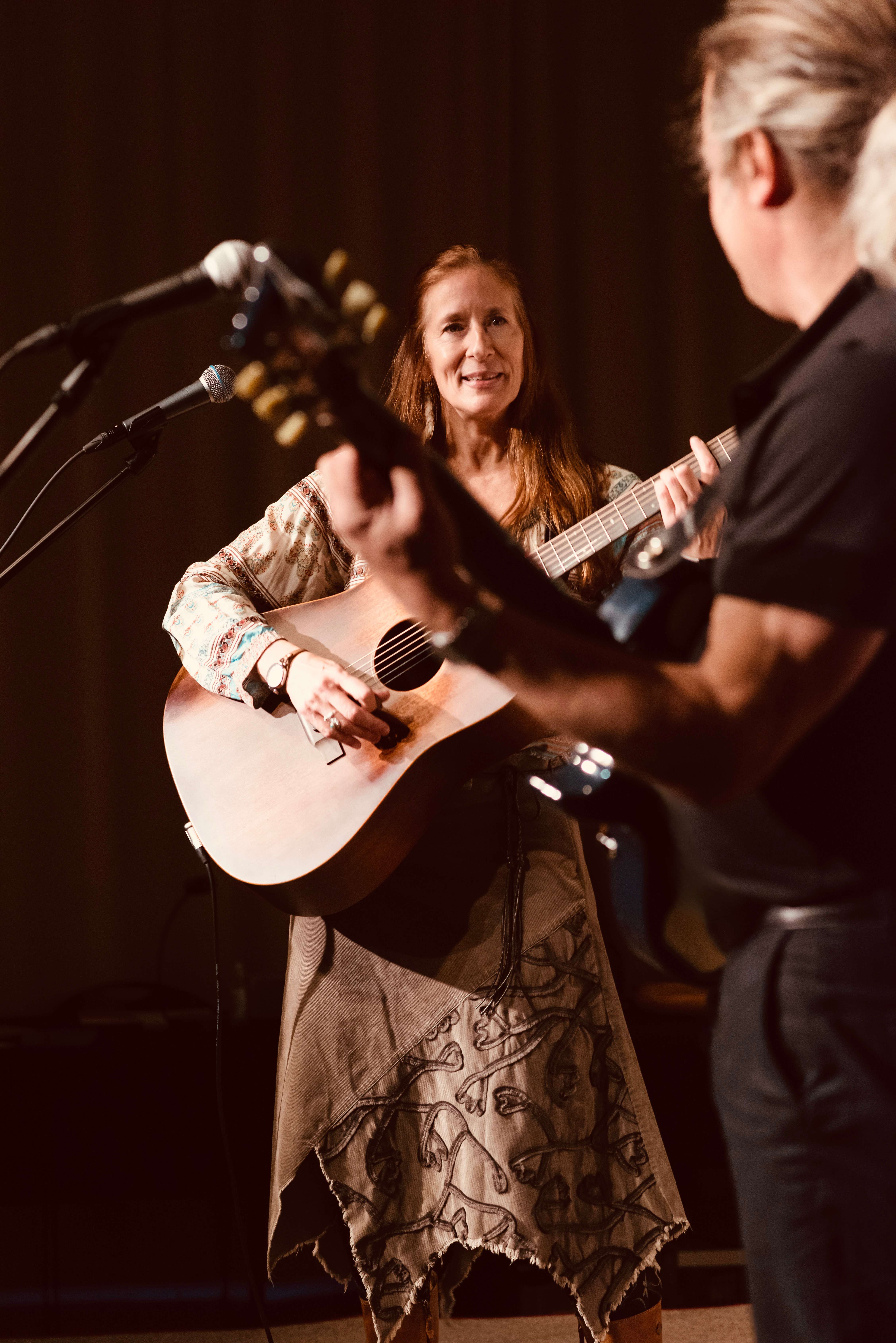 a woman playing an acoustic guitar