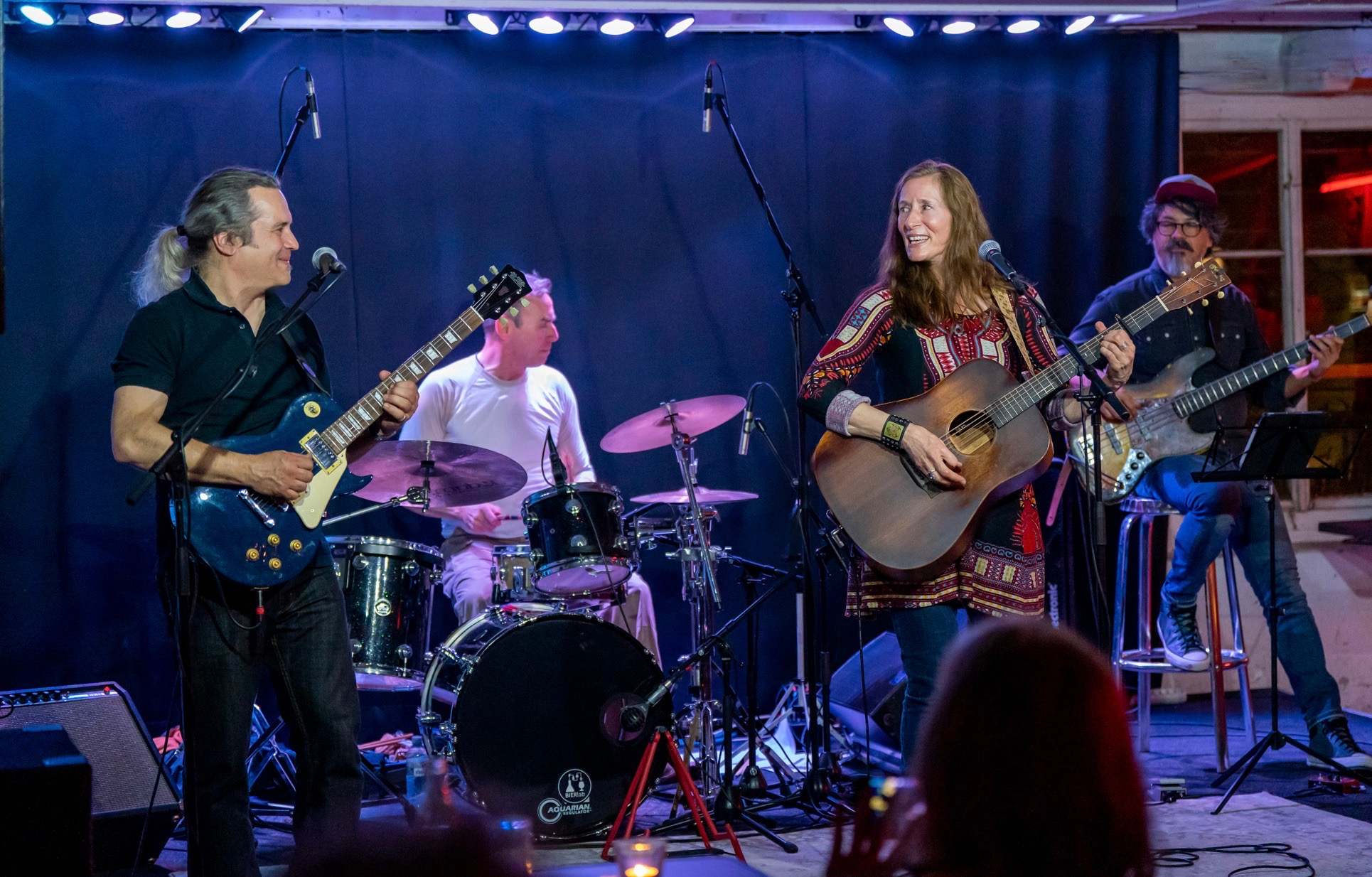 a group of people playing music on stage in front of a crowd