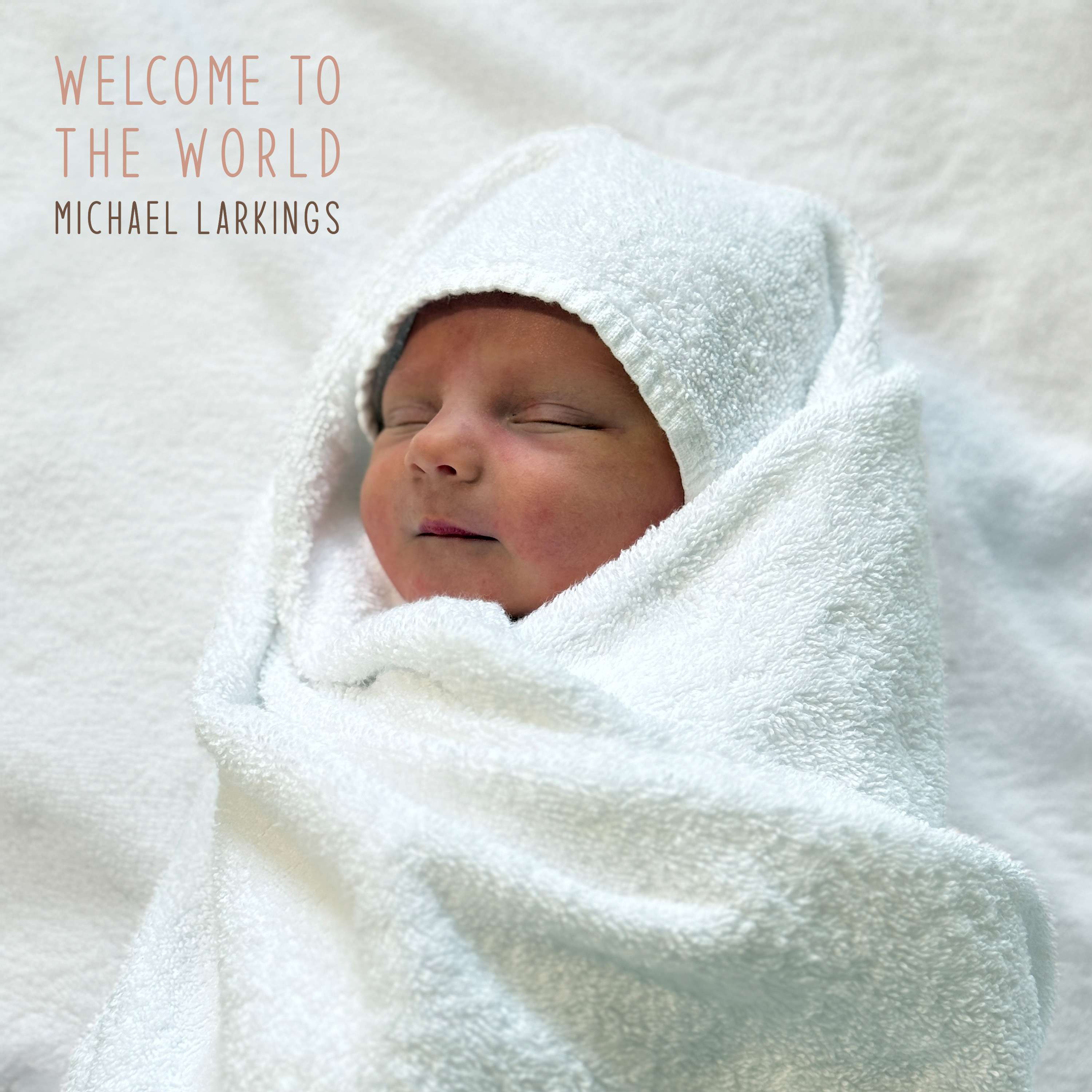 Michael Larkings - WELCOME TO THE WORLD: a newborn wrapped in a towel with the words welcome to the world
