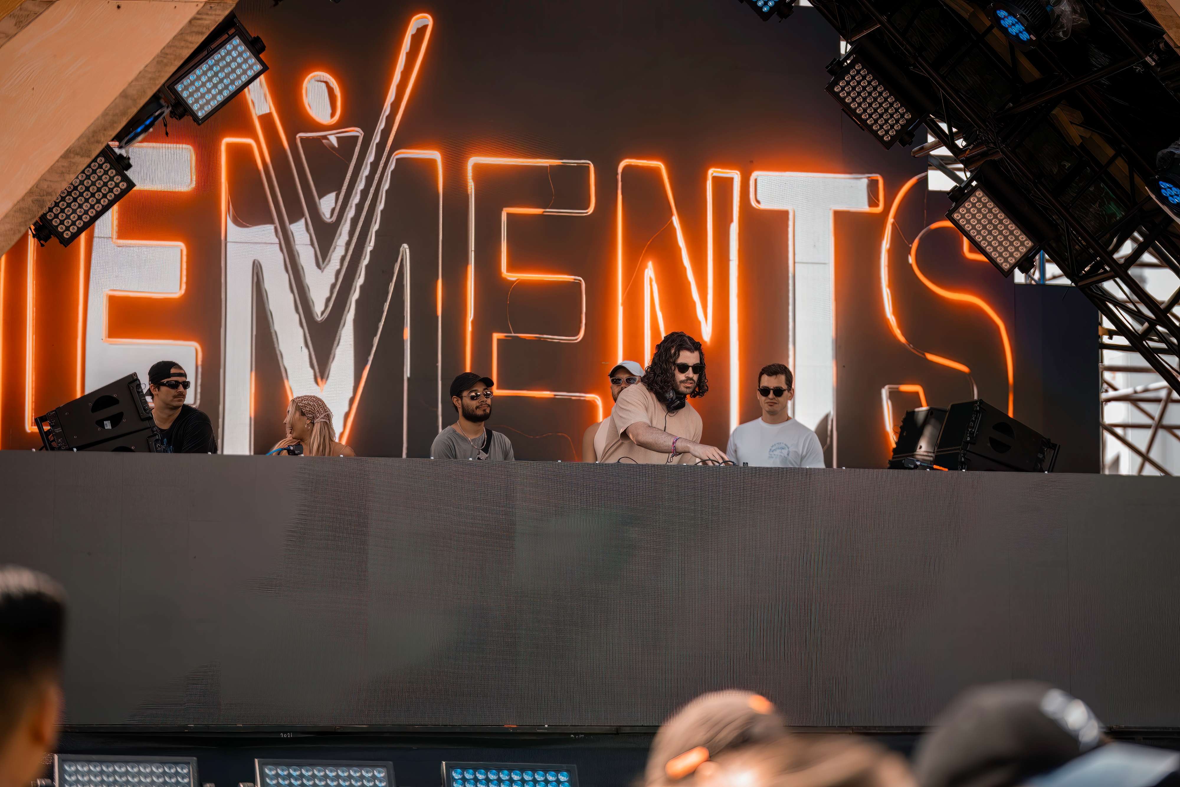 a group of people standing in front of a stage with the words elements on it