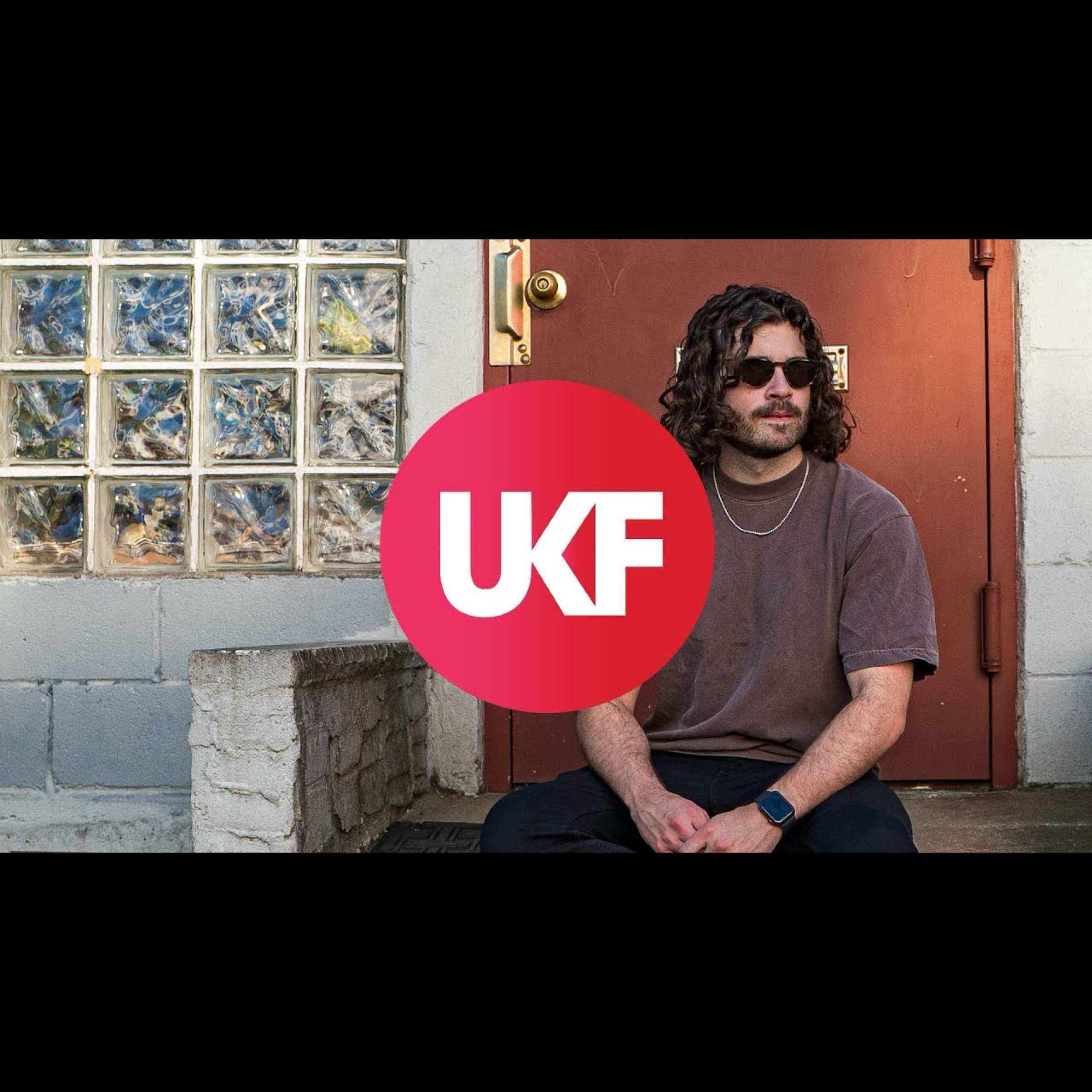 a man sitting on the steps of a door with the words ukf
