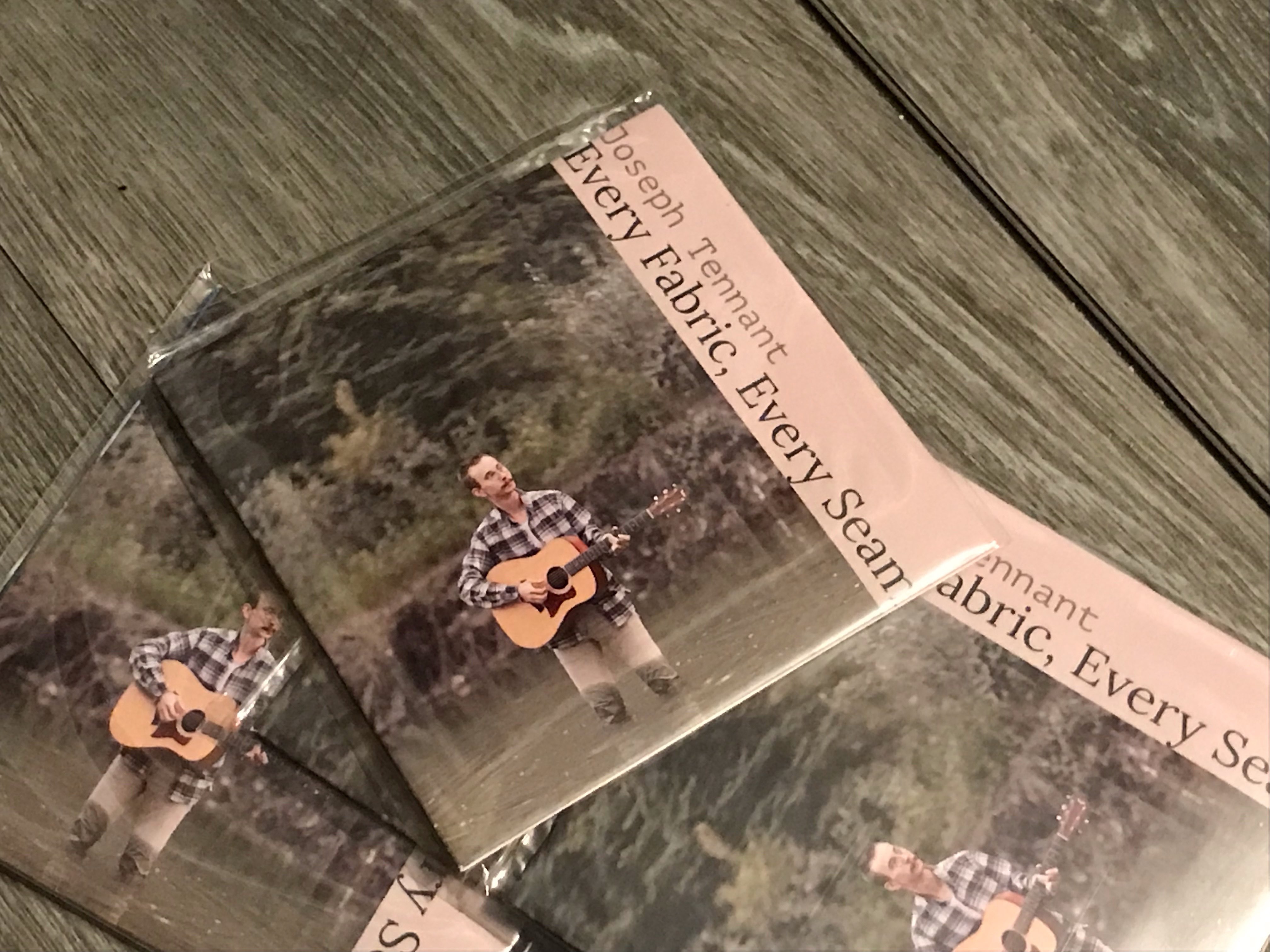 two cds with a picture of a man playing an acoustic guitar