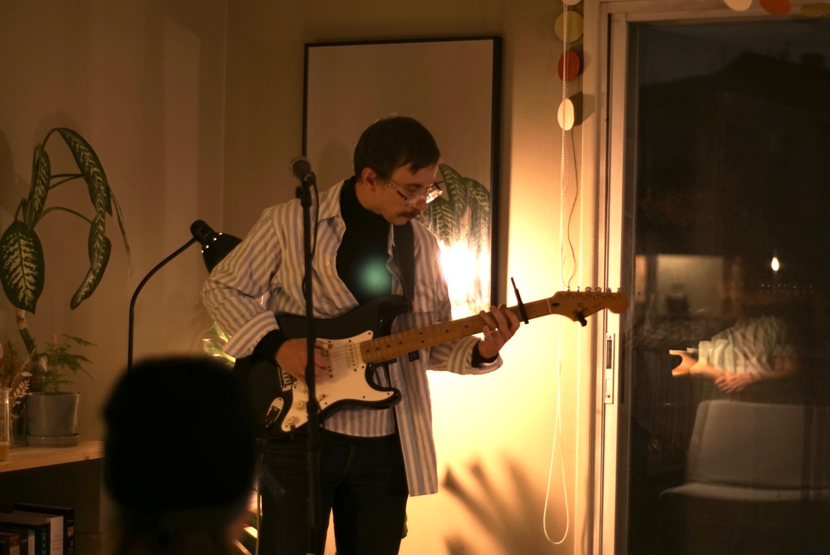 a man playing an electric guitar in a living room