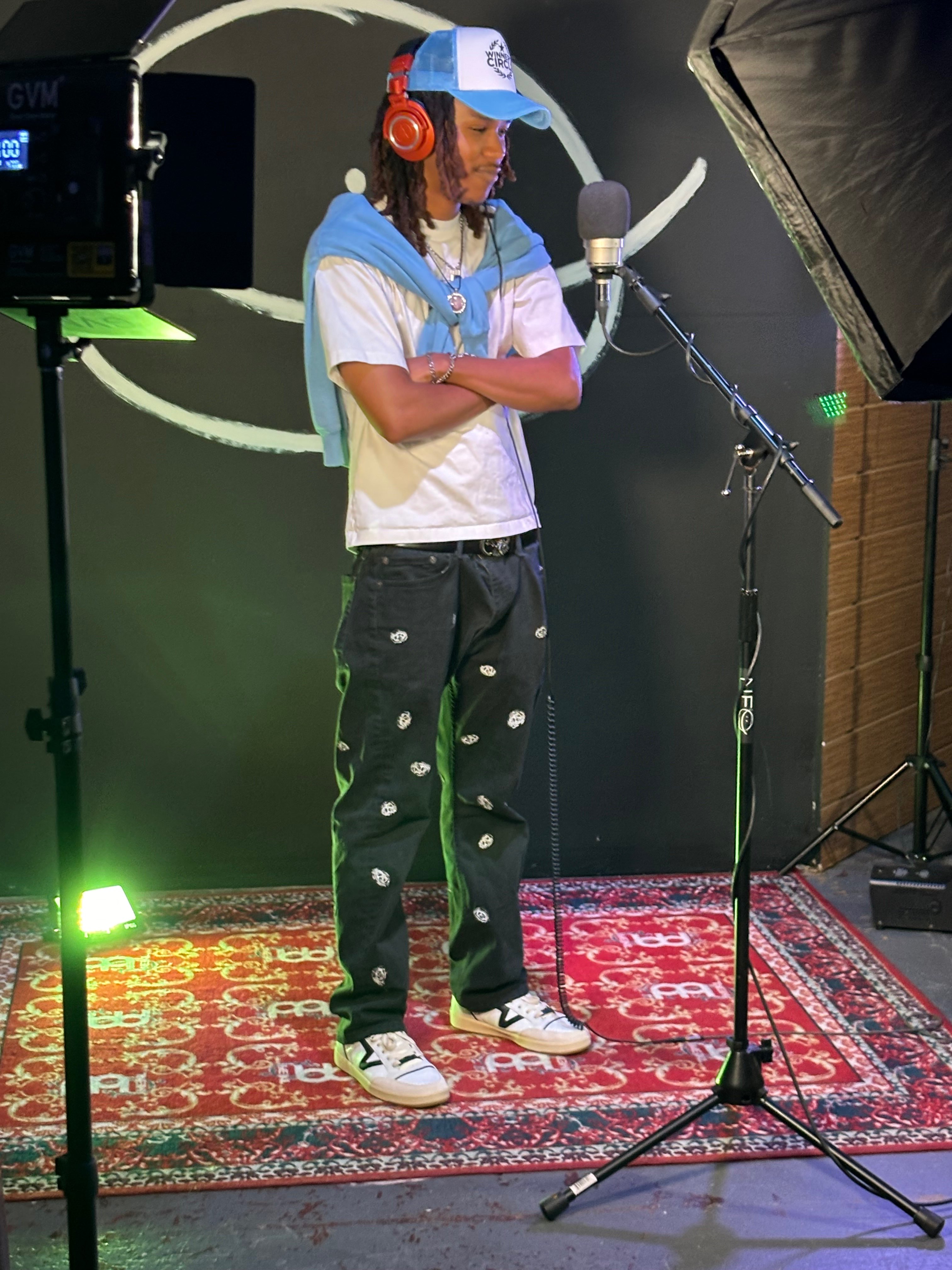 a man standing in front of a microphone in a recording studio