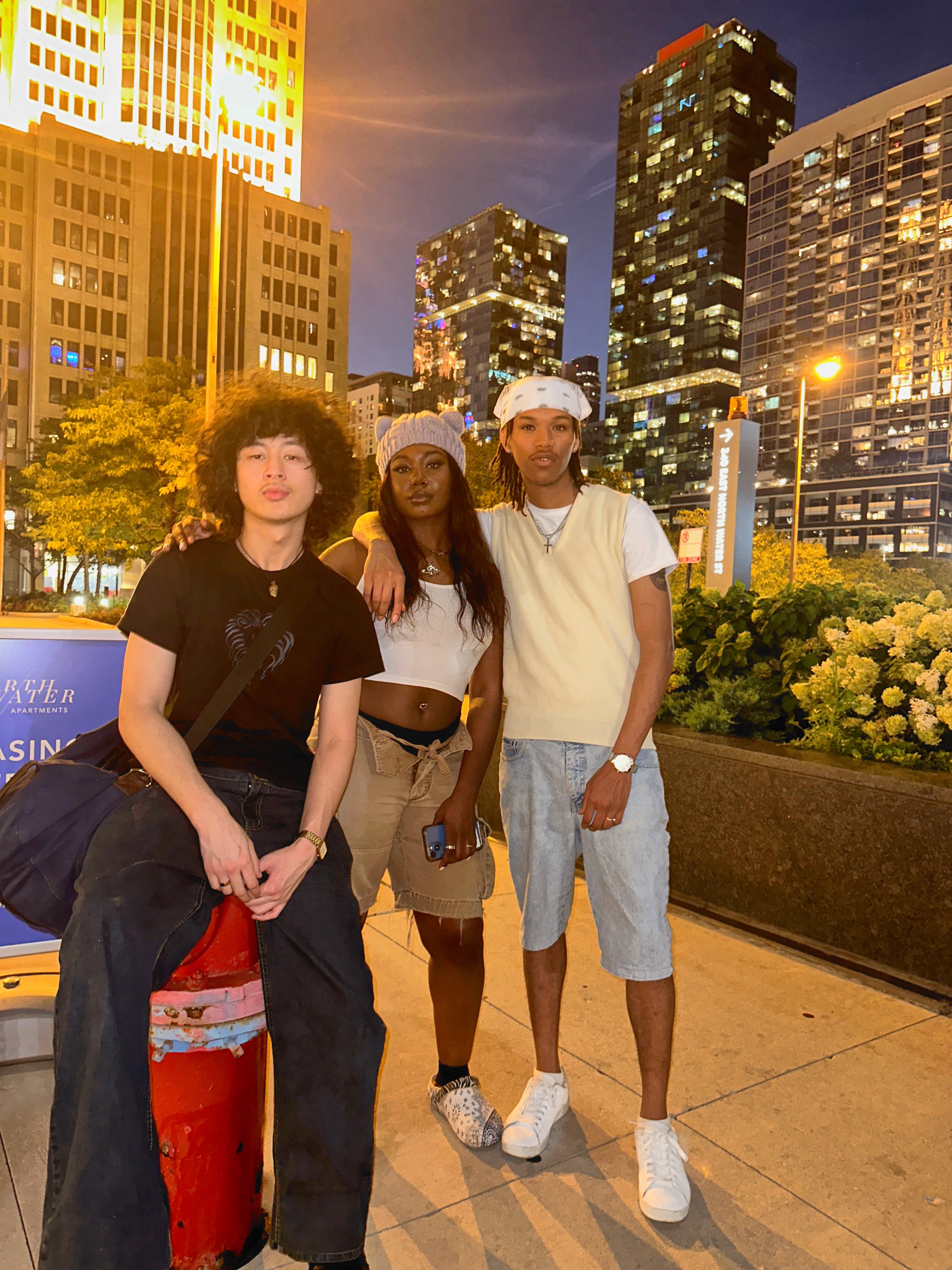 three people posing in front of a fire hydrant