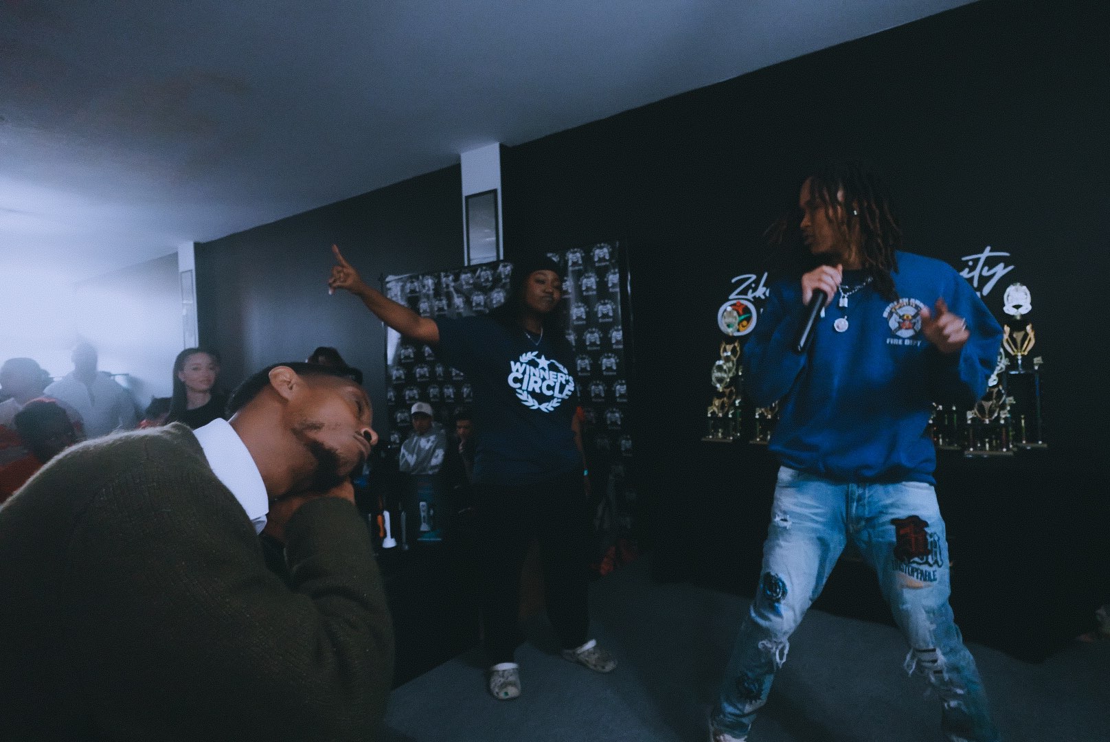 a group of people standing in a room with a microphone
