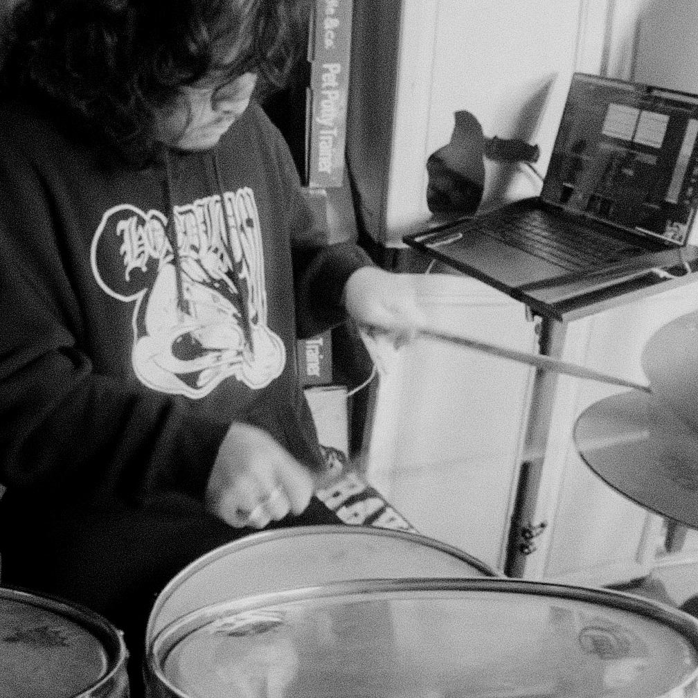 a black and white photo of a man playing drums