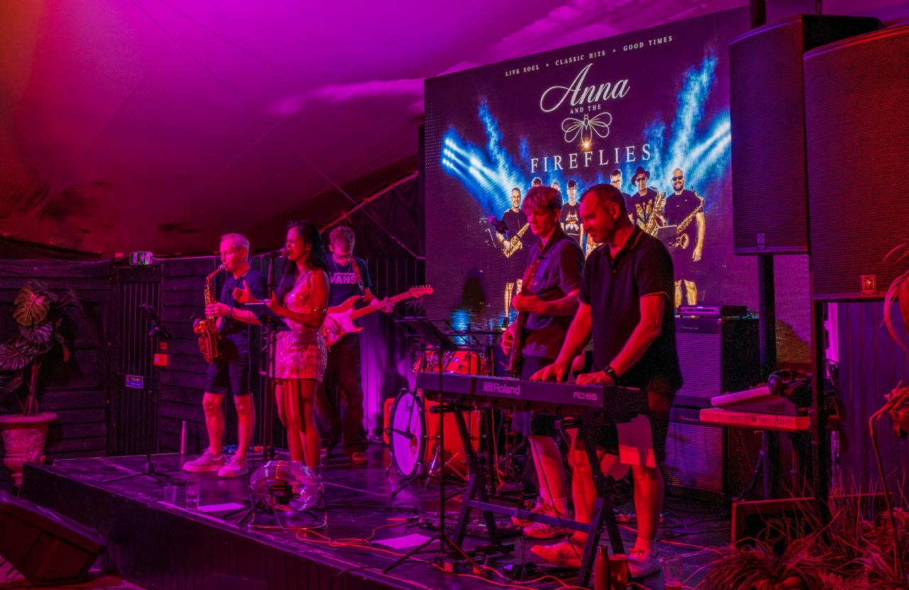 a group of people playing music on stage in a tent