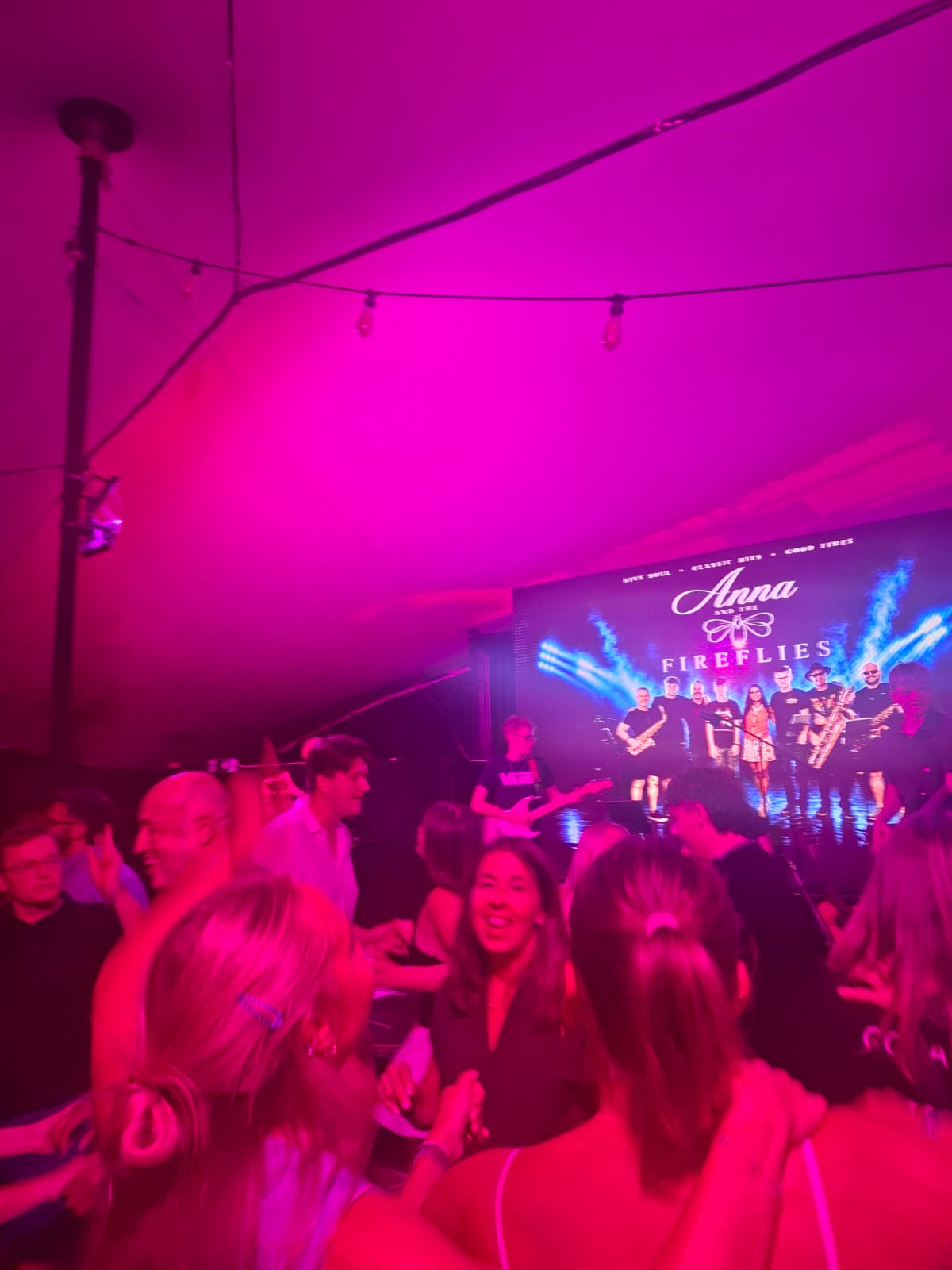 a group of people at a party under a purple light