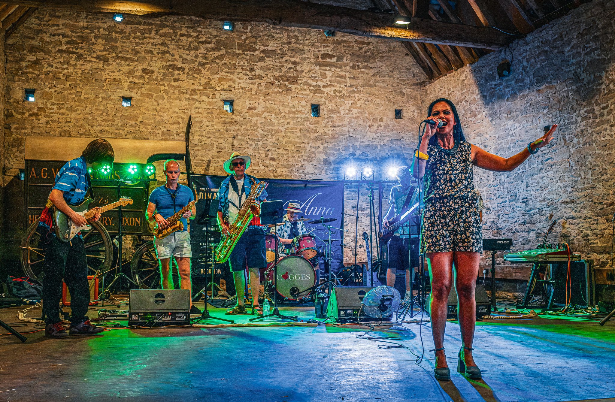 a woman singing on stage in a barn