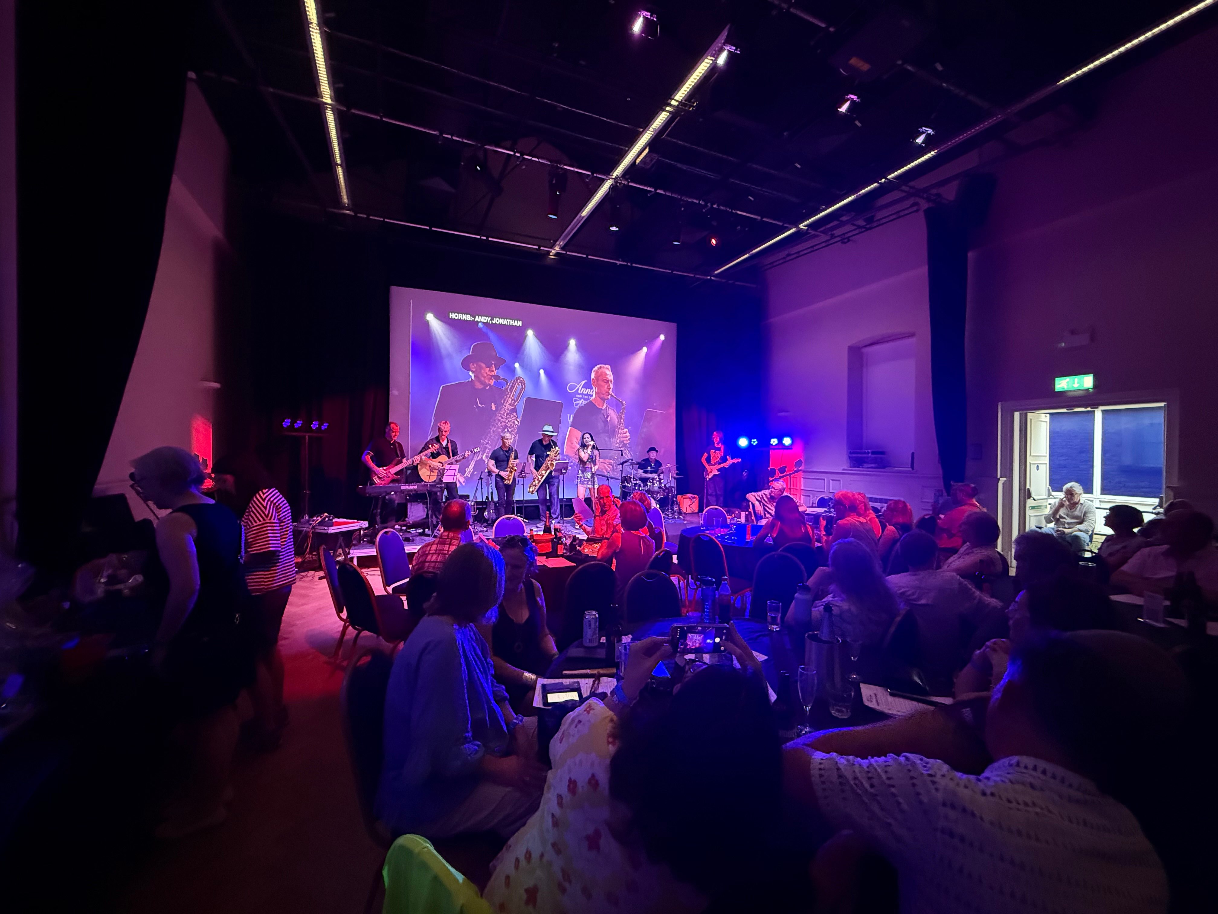 a group of people sitting at tables in a large auditorium
