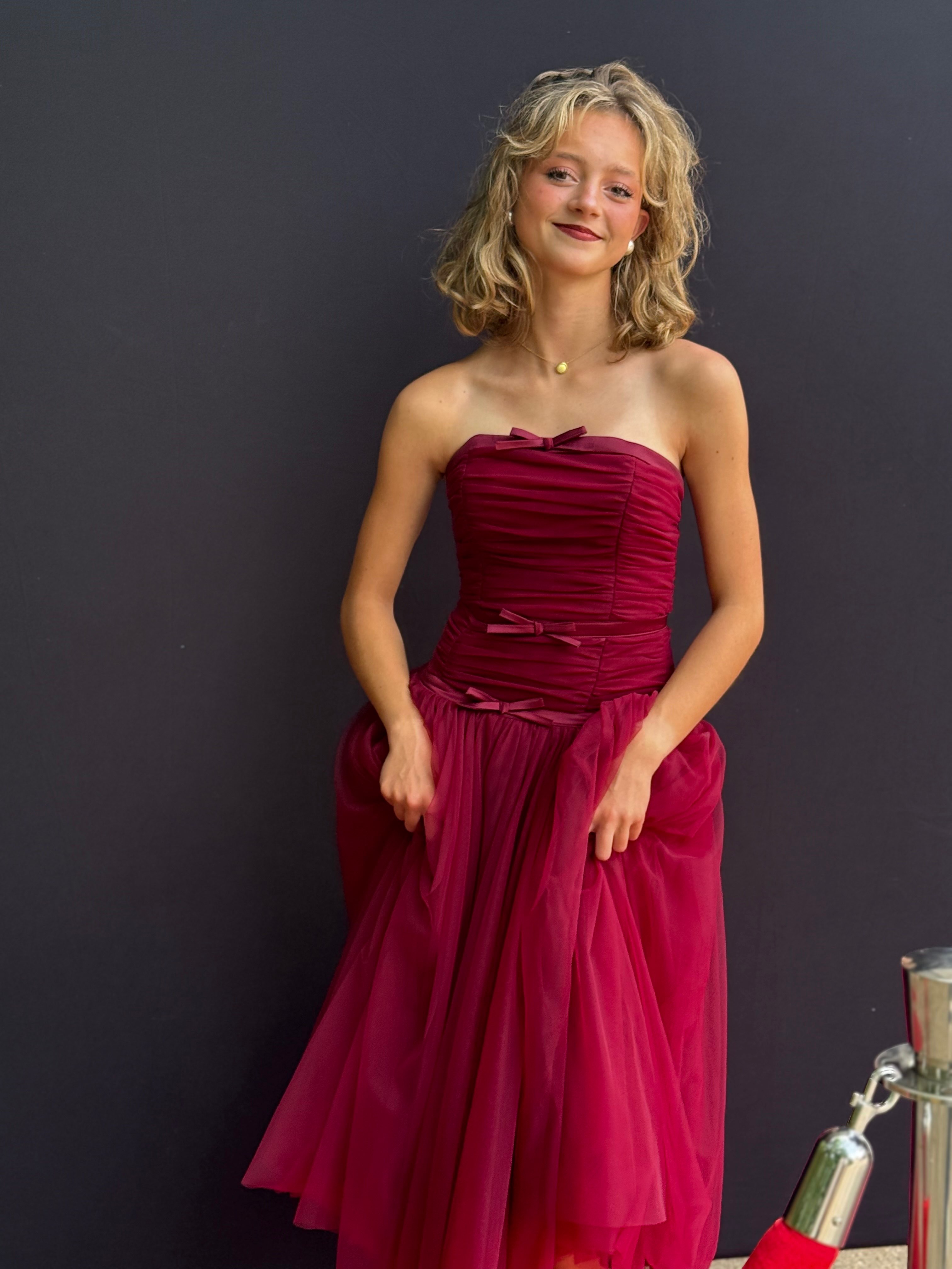 a young woman in a red dress posing for a photo