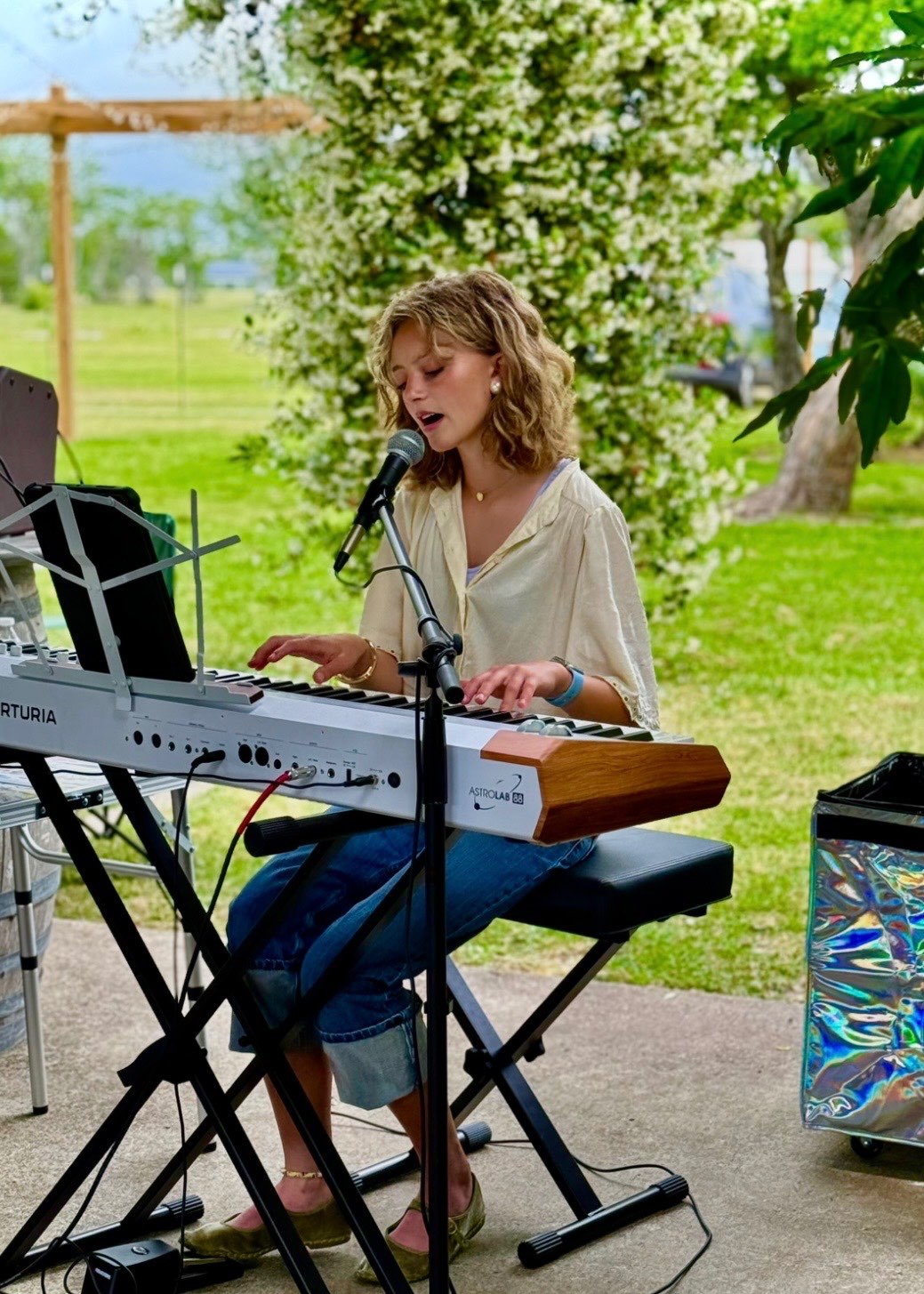 a woman playing a keyboard in front of a microphone