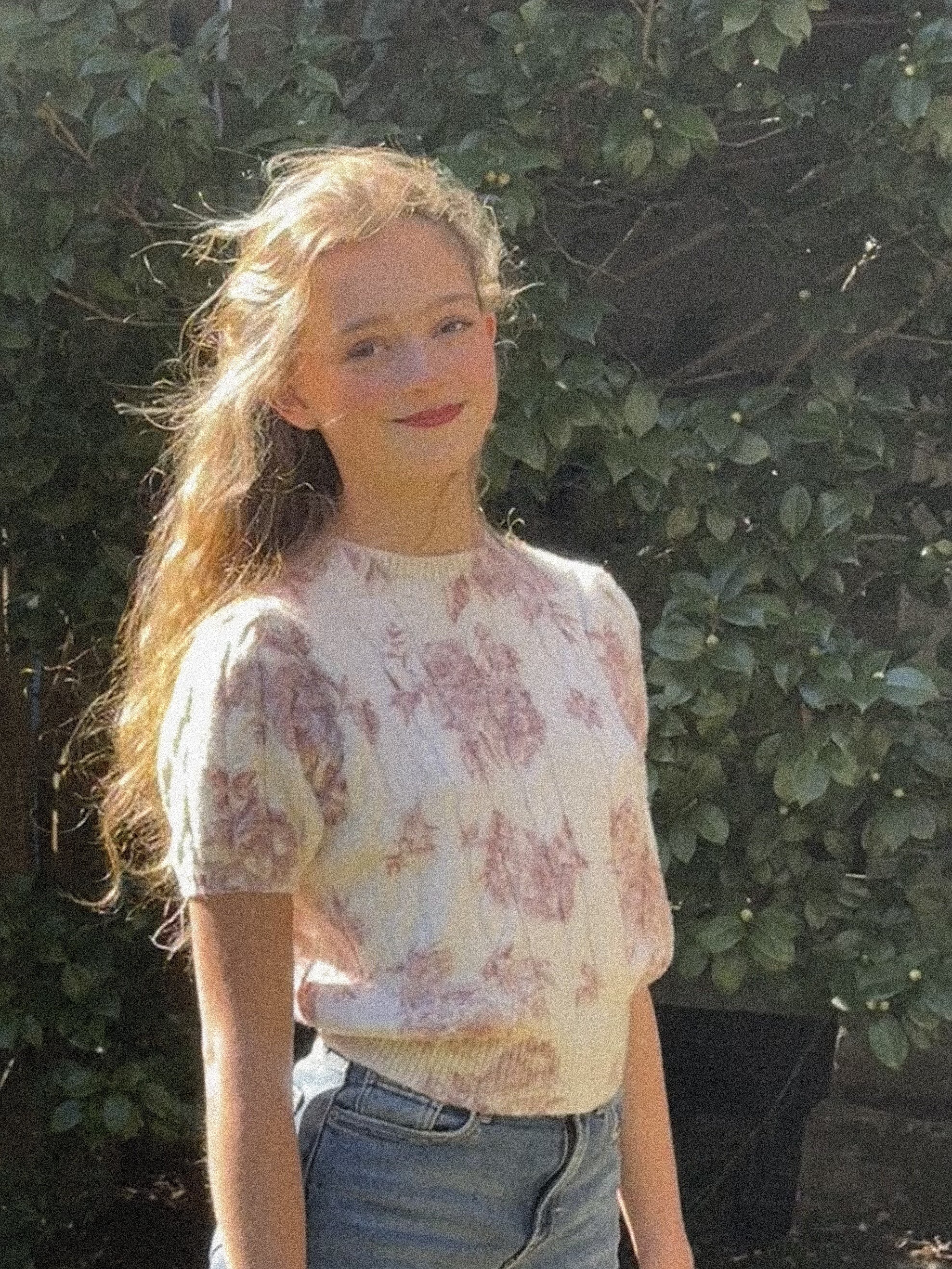 a young girl wearing jeans and a floral top