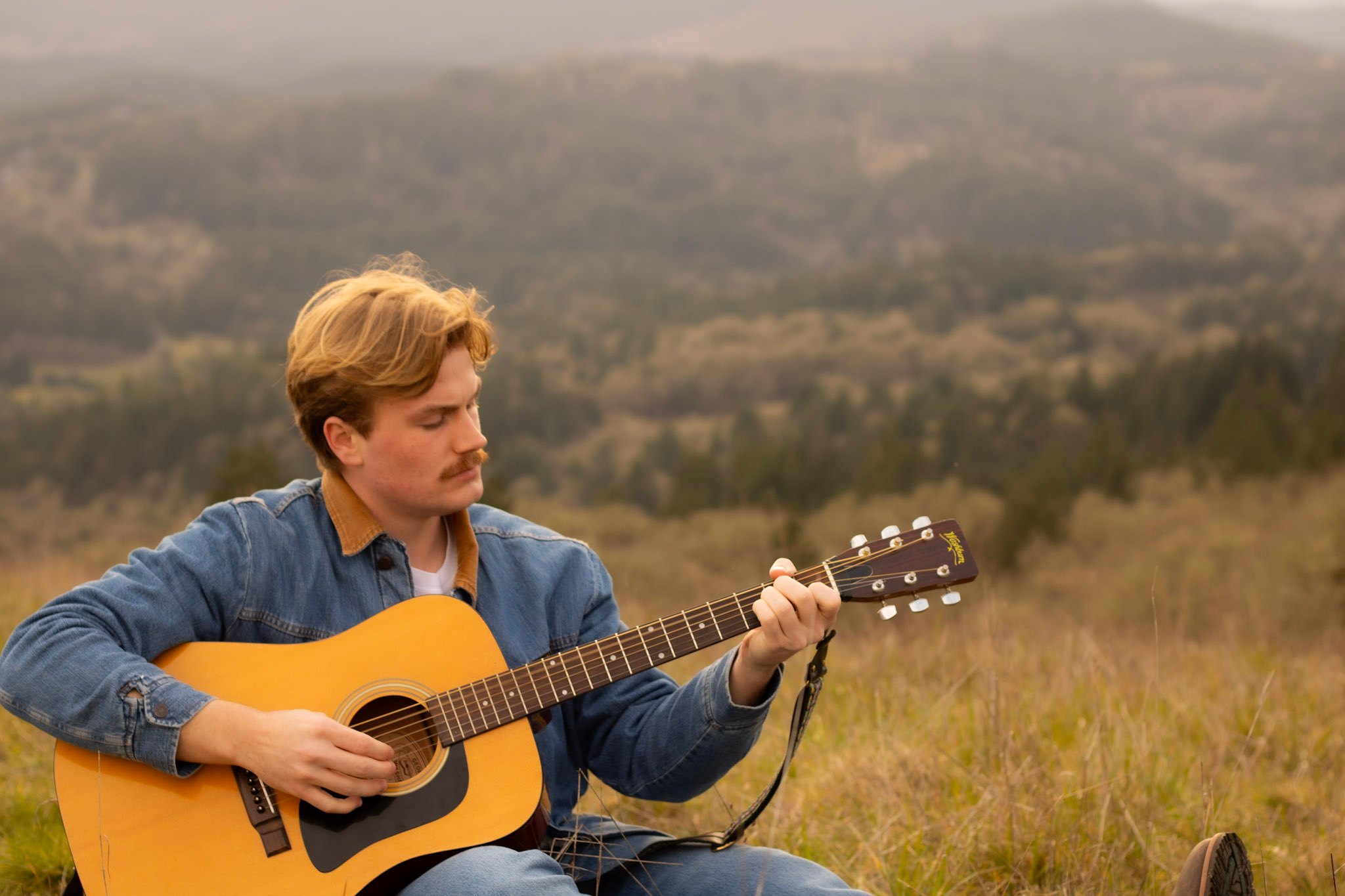 a man playing an acoustic guitar