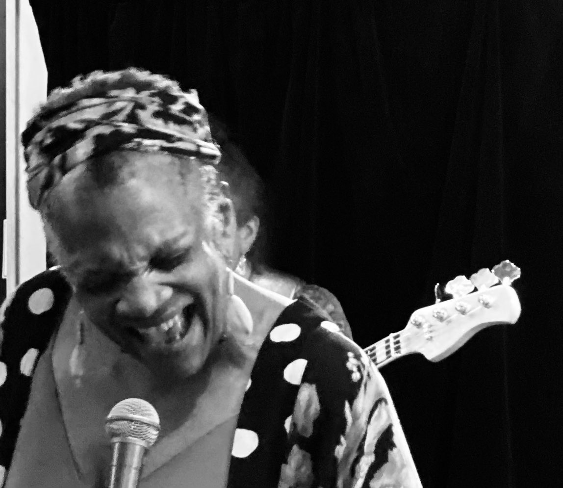 a black and white photo of a woman singing into a microphone