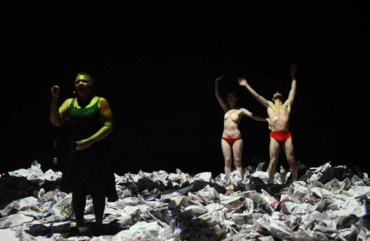a group of people standing in the middle of a pile of paper