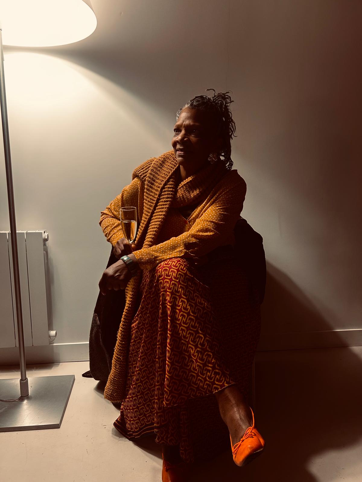 a woman sitting on a chair next to a lamp