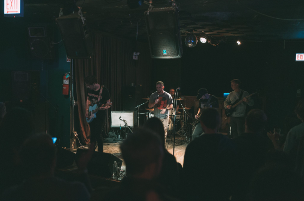 a group of people watching a band perform in a dark room