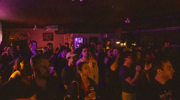 a crowd of people standing in a dark room