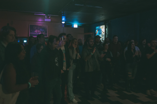 a crowd of people standing in a dark room