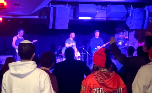 a group of people watching a band perform in a club