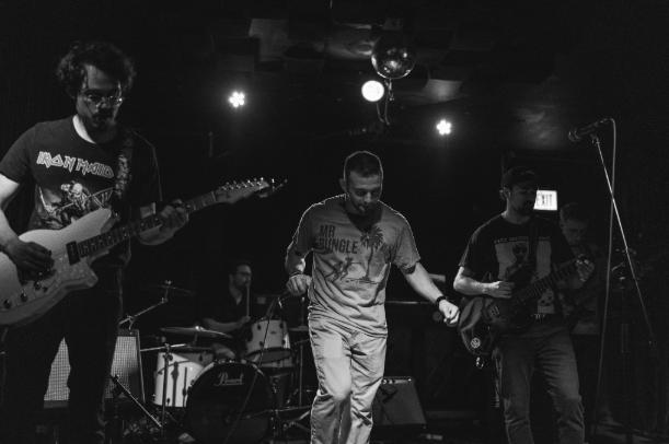 a black and white photo of a group of people playing music