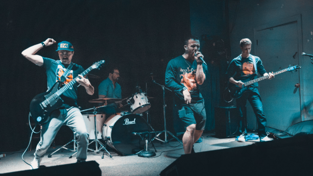a group of people on stage with guitars and drums