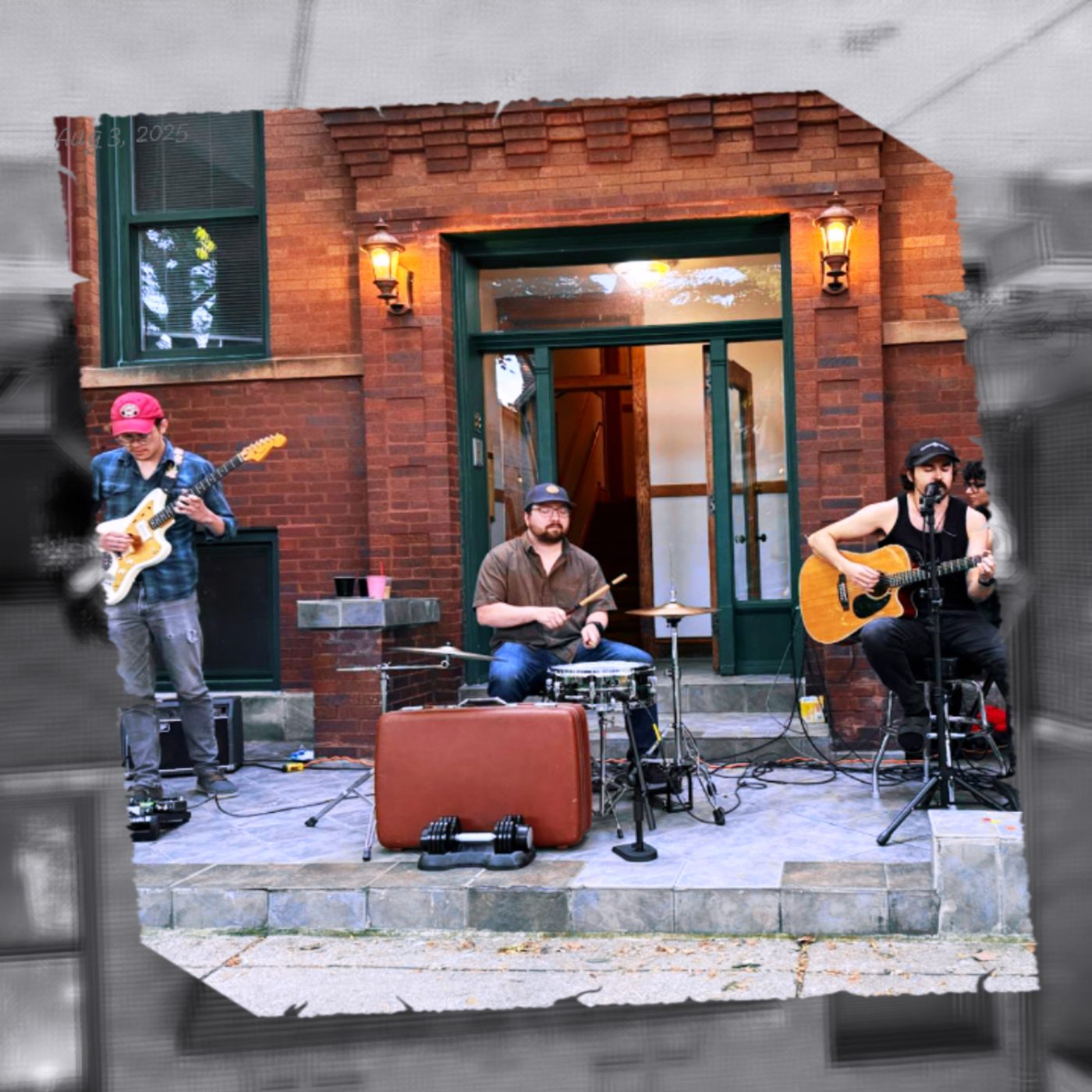 Barely Carvallo - Live and Barely Plugged: a group of people playing music in front of a brick building