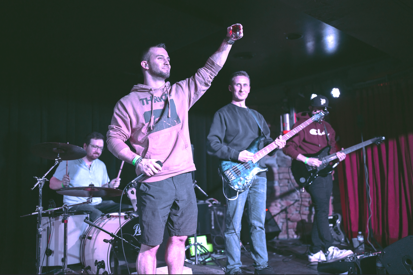 a group of people on stage with guitars and drums