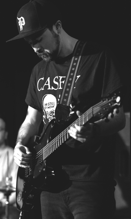 a black and white photo of a man playing a guitar