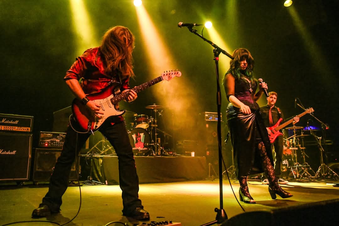 a group of people on stage with guitars and microphones