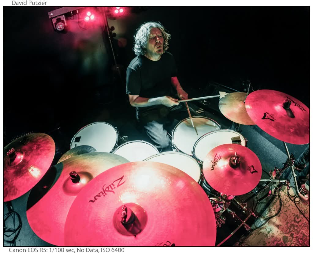 a man playing drums in a dark room