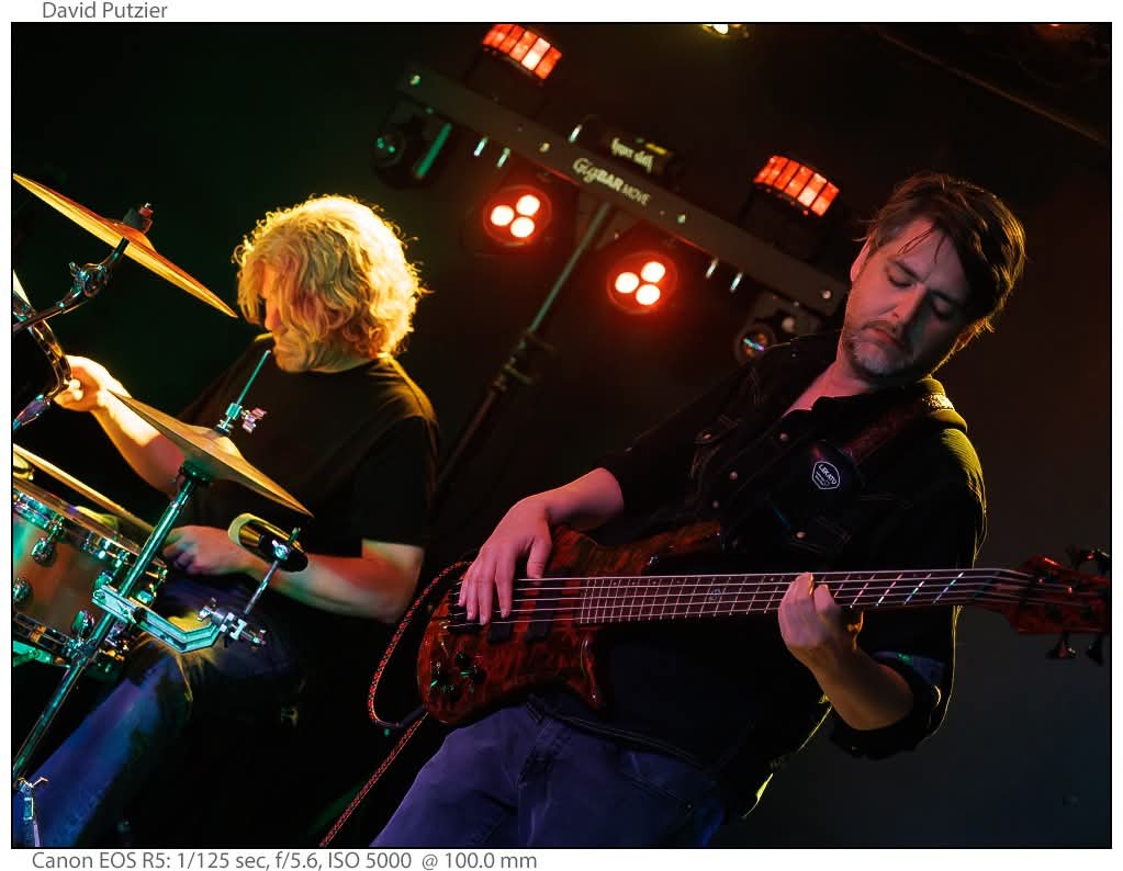 two men playing bass on stage