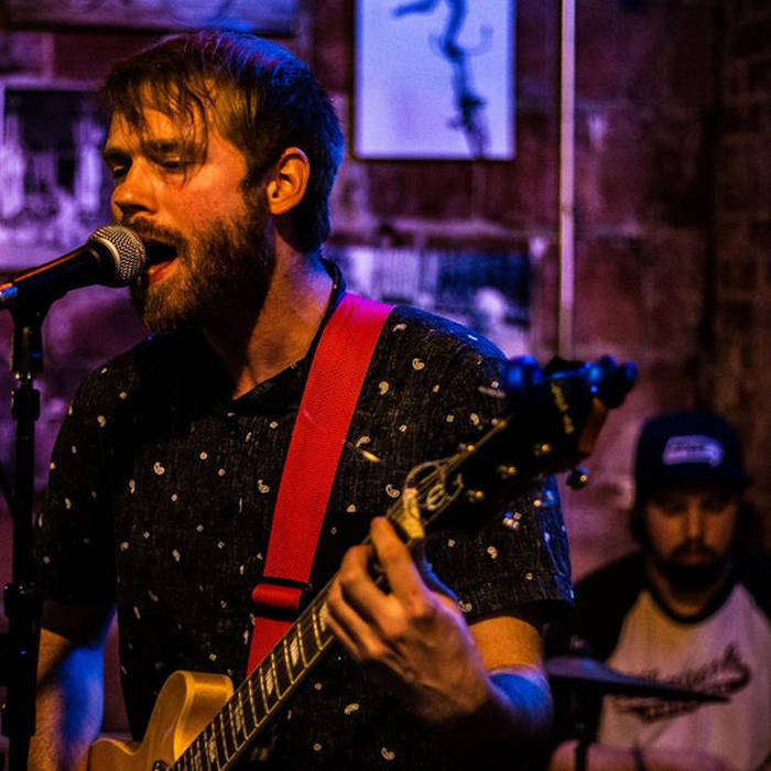 a man with a beard singing into a microphone