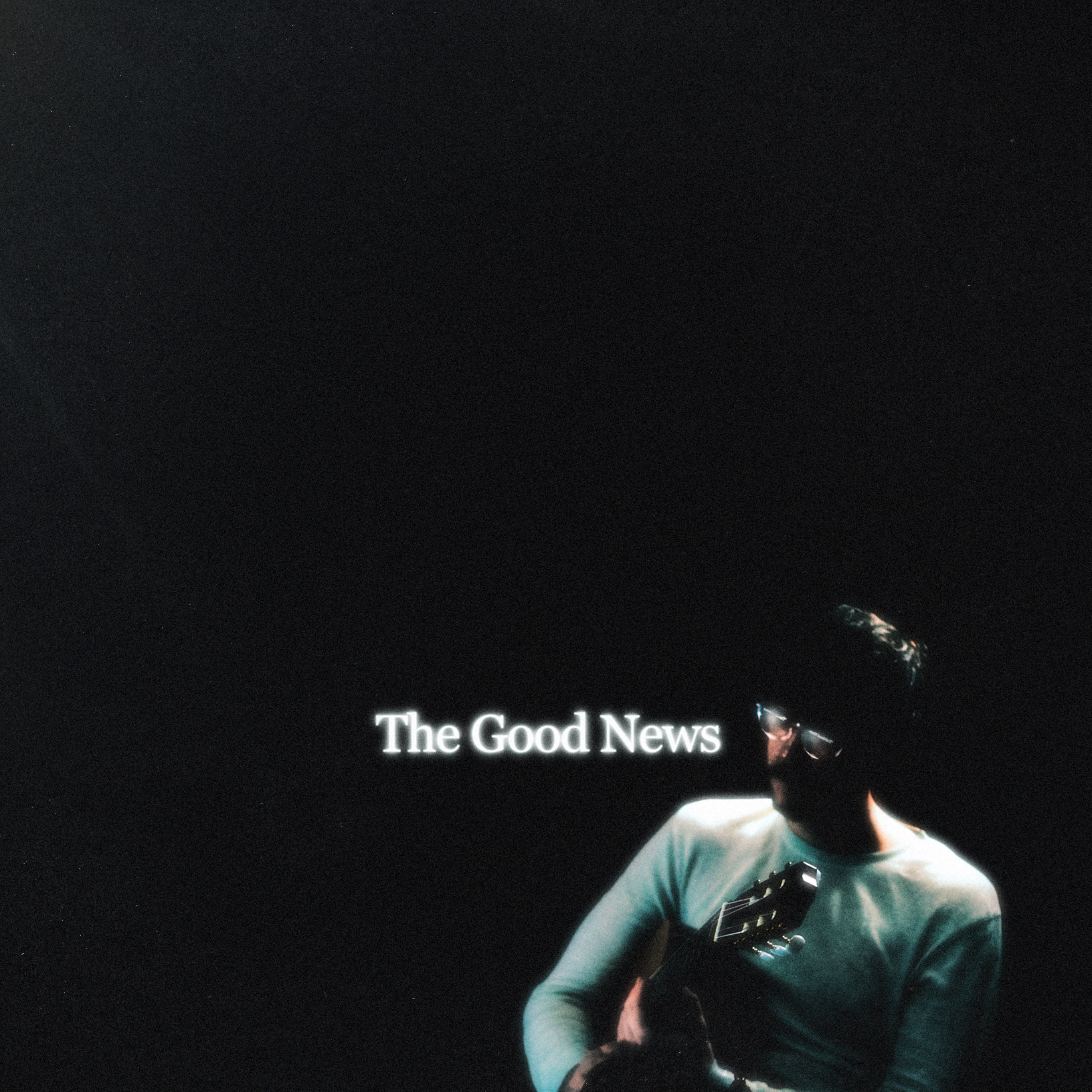 an image of a man holding a guitar with the words the good news