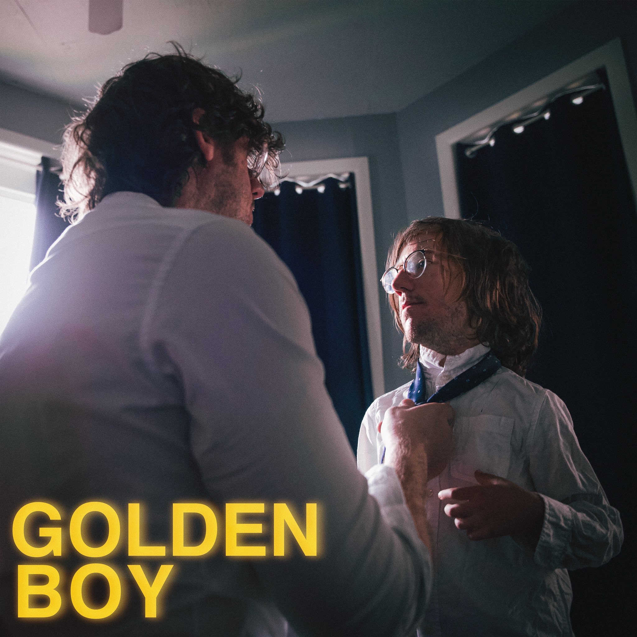 a man is adjusting a young boy's tie