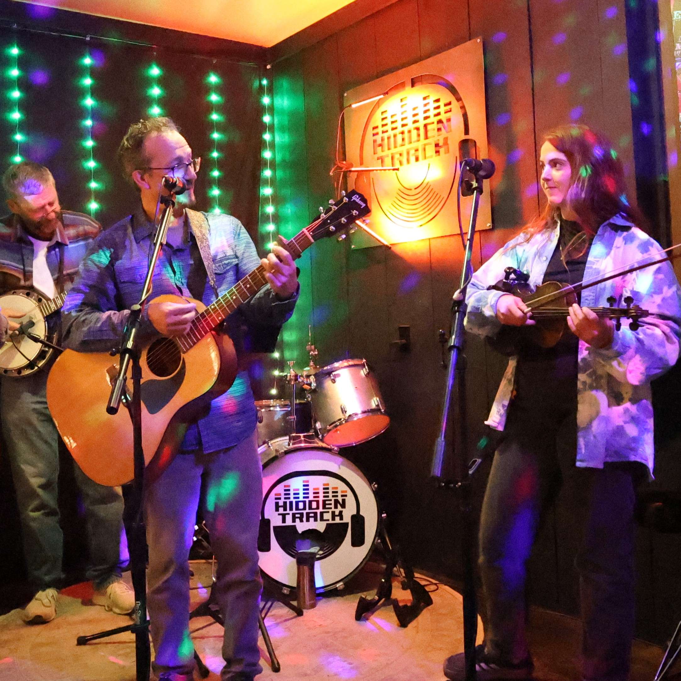 a group of people playing banjos and guitars in a room