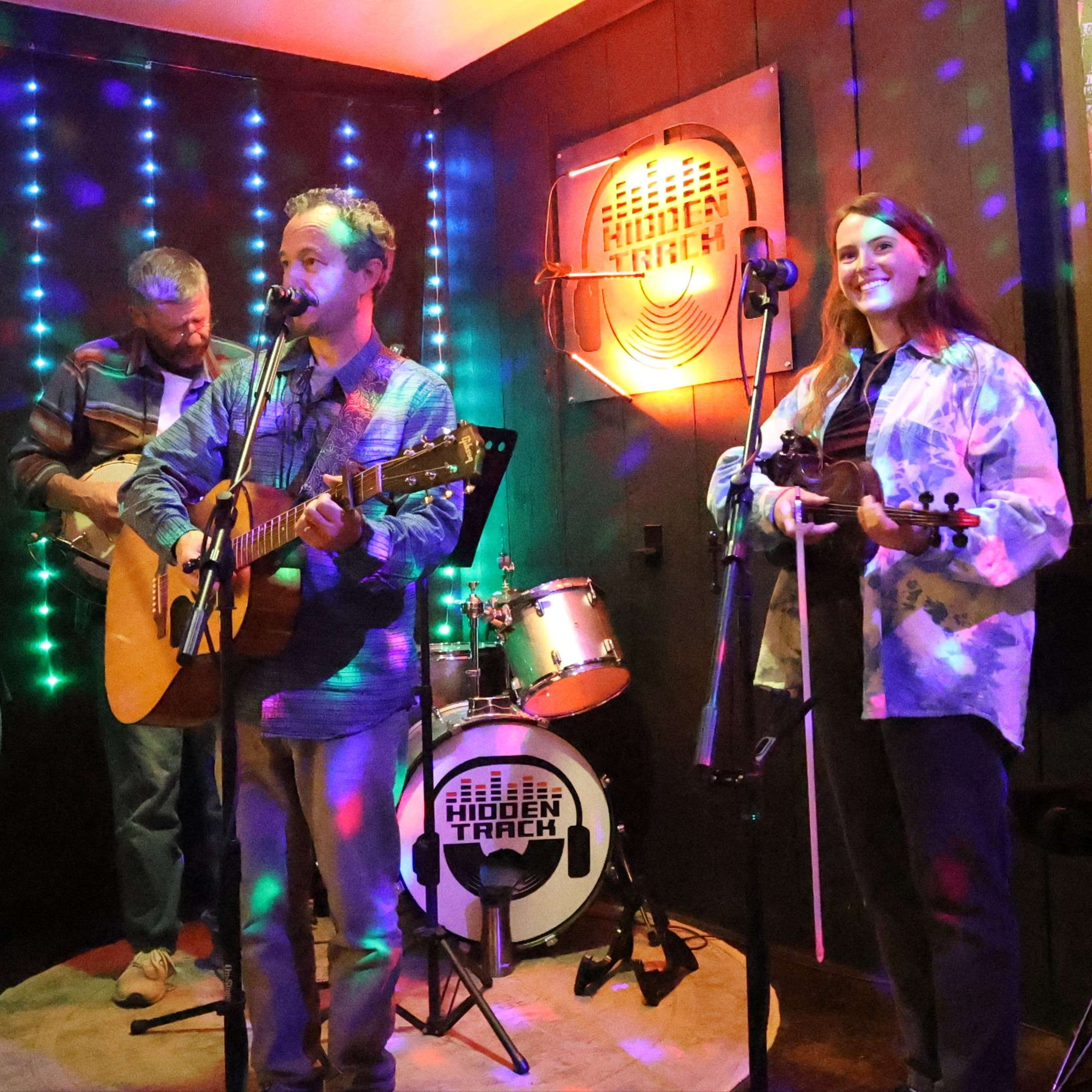 a group of people singing and playing a musical instrument in a room